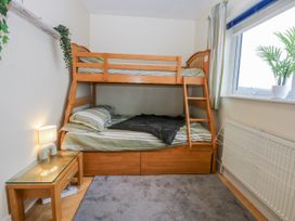 A bedroom with a bunk bed and nightstand at Snowdonia View in Pwllheli