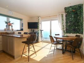 A kitchen with a dining table and chairs at Snowdonia View in Pwllheli