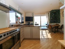 A kitchen with appliances and dining area at Snowdonia View in Pwllheli