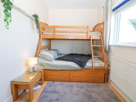 A bedroom with a bunk bed and side table at Snowdonia View in Pwllheli