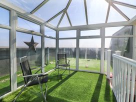 A conservatory with chairs and a star decoration at Snowdonia View in Pwllheli