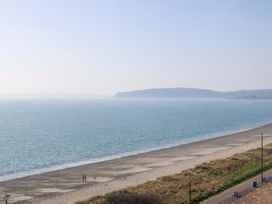 A beach with people walking and a dog at Snowdonia View in Pwllheli