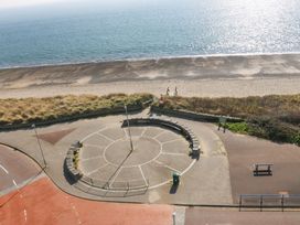A beach with a circular seating area leading to the sea at Snowdonia View in Pwllheli