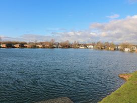 A view of a lake with houses and trees at Fairways 22, Lincoln