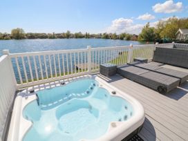 A hot tub on a deck with a view of a lake at Fairways 22 in Tattershall