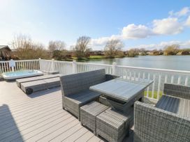 A deck with outdoor furniture and a hot tub at Fairways 22 in Tattershall