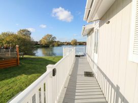 An outdoor balcony with a view of water and trees at Fairways 22 in Tattershall