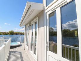 An outdoor area with a hot tub and view of water at Fairways 22 in Tattershall