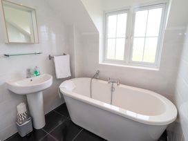 A bathroom with a bathtub and washbasin at 35 Longbeach Drive