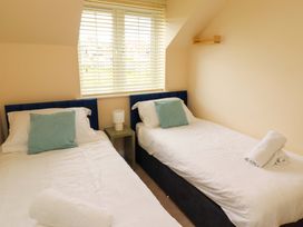 A bedroom with twin beds and a lamp at 35 Longbeach Drive