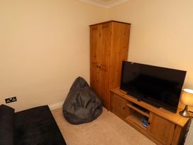 A living room with furniture including a television and a wardrobe at 35 Longbeach Drive