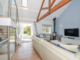 A living room with a sofa and a television at The Cowshed in Portscatho