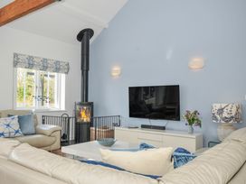 A living room with a fireplace and television at The Cowshed in Portscatho