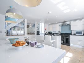 A kitchen with a stove, oven, and dining table at The Cowshed in Portscatho