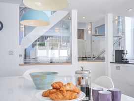 A kitchen with croissants and coffee on the table at The Cowshed in Portscatho