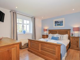 A bedroom with a bed and bedside tables at The Cowshed in Portscatho