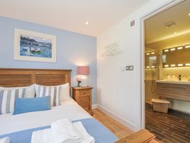 A bedroom with a bed and an adjoining bathroom at The Cowshed in Portscatho