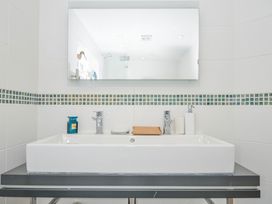 A sink and mirror with toiletries in the bathroom at The Cowshed in Portscatho