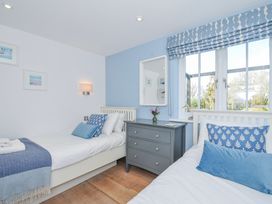 A bedroom with two beds and a dresser at The Cowshed in Portscatho