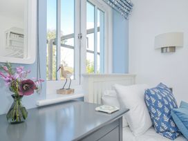 A bedroom with a bed and window at The Cowshed in Portscatho