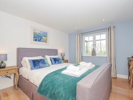 A bedroom with a bed and bedside tables at The Cowshed in Portscatho