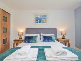 A bedroom featuring a bed with pillows and bedside tables at The Cowshed in Portscatho