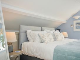 A bedroom with a bed and lamp at The Cowshed in Portscatho