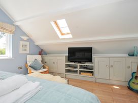 A bedroom with a bed and television at The Cowshed in Portscatho