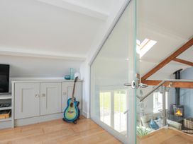 A living room with a television and a guitar at The Cowshed in Portscatho