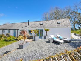 An outdoor area with deck chairs and planters at The Cowshed in Portscatho