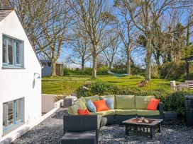 A garden with a sofa and coffee table at The Cowshed in Portscatho