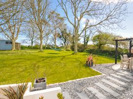 A garden with a hammock and seating area at The Cowshed in Portscatho