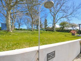 An outdoor shower and grassy area at The Cowshed in Portscatho