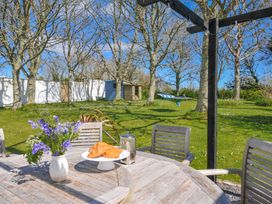 A garden with a table of croissants and flowers at The Cowshed in Portscatho