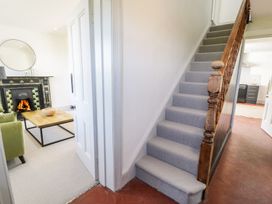 A living room with a staircase and fireplace at Ty Mawr Farm in Llanfairpwllgwyngyll