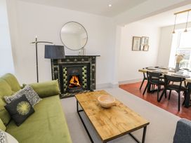 A living room with a fireplace and dining area at Ty Mawr Farm in Llanfairpwllgwyngyll