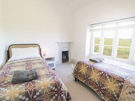 A bedroom with two beds and a window at Ty Mawr Farm in Llanfairpwllgwyngyll