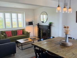 A living room with a green sofa and wooden dining table at Ty Mawr Farm Penmynydd near Llanfairpwllgwyngyll