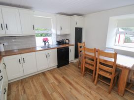A kitchen with cabinets and a dining table at Greenfield House in Aughavas, County Leitrim