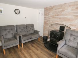 A snug with seating and a fireplace at Greenfield House Aughavas, County Leitrim