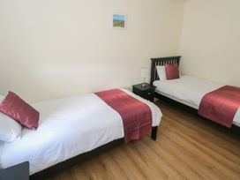A bedroom with two single beds and a nightstand at Greenfield House in Aughavas, County Leitrim