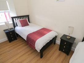 A bedroom with a single bed and nightstands at Greenfield House, Aughavas, County Leitrim