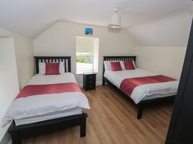 A bedroom with two beds and a nightstand at Greenfield House in Aughavas, County Leitrim