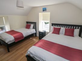A bedroom with two beds and a nightstand at Greenfield House in Aughavas, County Leitrim