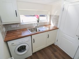 A laundry room with a washing machine and sink at Greenfield House Aughavas, County Leitrim