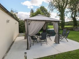 A gazebo with chairs and a table outside at Greenfield House Aughavas, County Leitrim