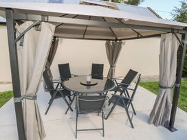 An outdoor seating area with a gazebo and table at Greenfield House Aughavas, County Leitrim