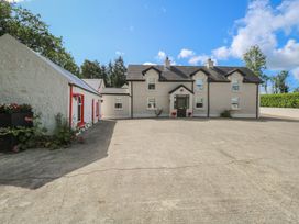 A house with a concrete driveway and garden at Greenfield House in Aughavas, County Leitrim