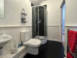 A bathroom with a shower toilet and wash basin at Too Hoots in Lligwy