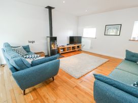 A living room with a fireplace and television at Too Hoots in Lligwy